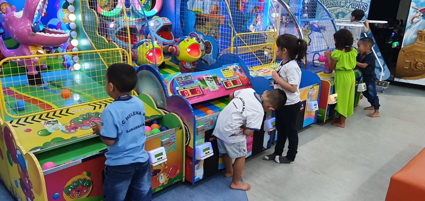 Grupo de crianças de uniforme brincando juntas nas máquinas do parque