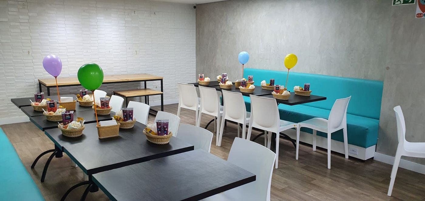 Mesas do salão exclusivo preparadas para o lanche da turma